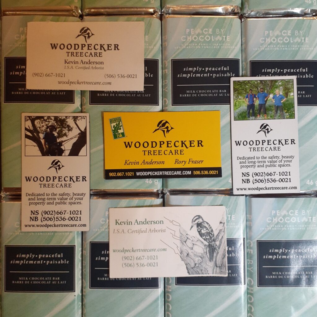 A grid of Peace By Chocolate bars makes up the background, while five different business cards for Woodpecker Tree Care rest on top of them.